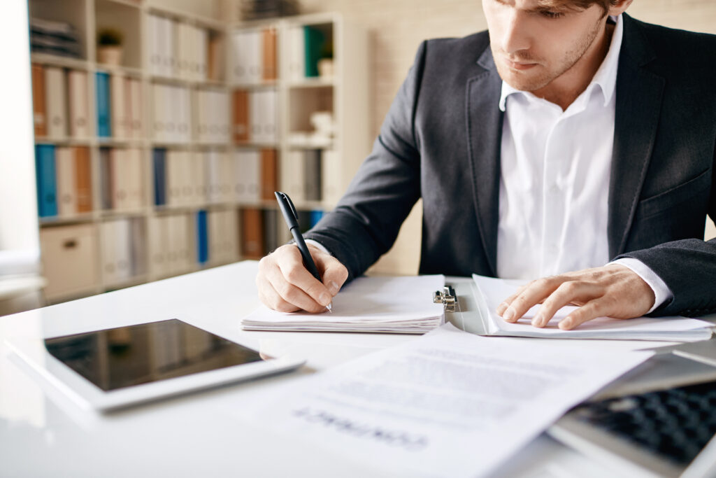 Focused business owner drafting a detailed business plan at a desk, preparing documents to secure funding and support future growth.
