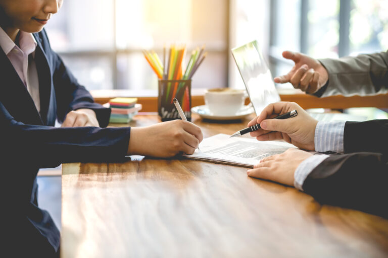 Entrepreneur signing a business purchase agreement after a thoughtful review process, representing a well-planned and informed acquisition decision.