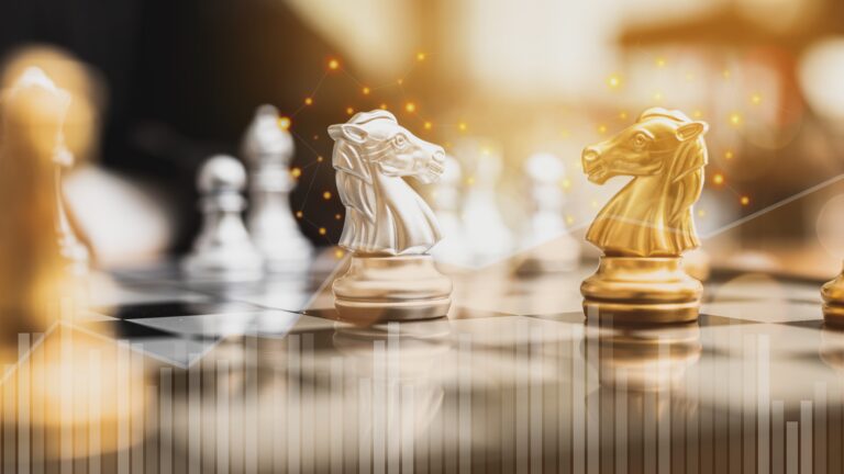 Gold and silver knight chess pieces face off on a chessboard, illuminated by a warm strategic glow. A symbolic representation of two competing buyer types—Strategic and Financial—each with distinct motives and tactics. Subtle data visuals overlay the scene, reinforcing the calculated nature of M&A decisions. This image underscores the need for sellers to think several moves ahead when choosing the right buyer for their business.