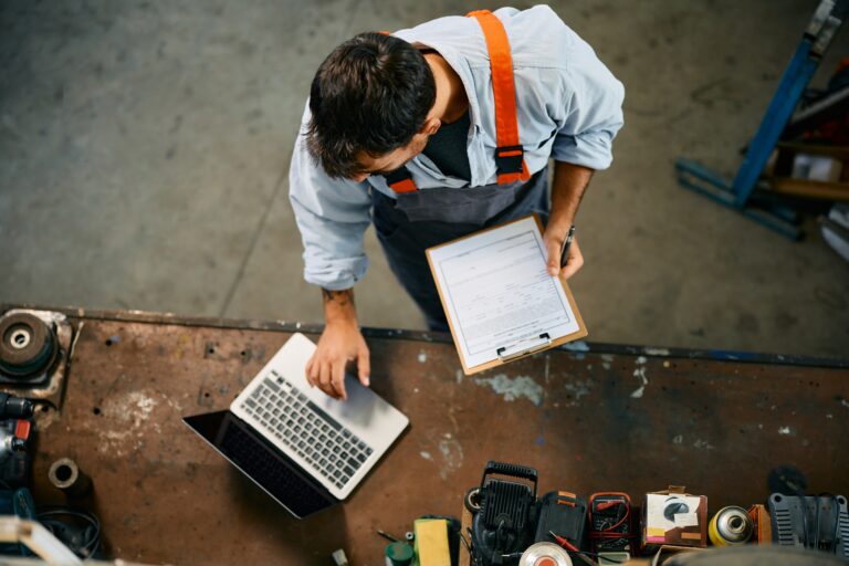 Blue-collar business owner reviewing financial records and operations, representing private equity roll-ups, bolt-on acquisitions, EBITDA growth, and business sale preparation.