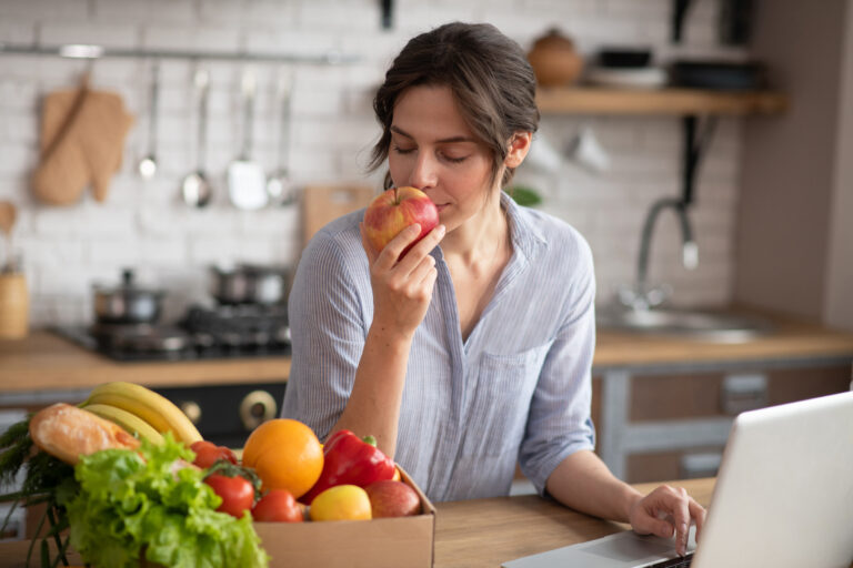 Business owner reviewing financial and strategic growth opportunities from home office while holding an apple, symbolizing the “Second Bite of the Apple” concept in private equity recapitalizations and rollover equity transactions.
