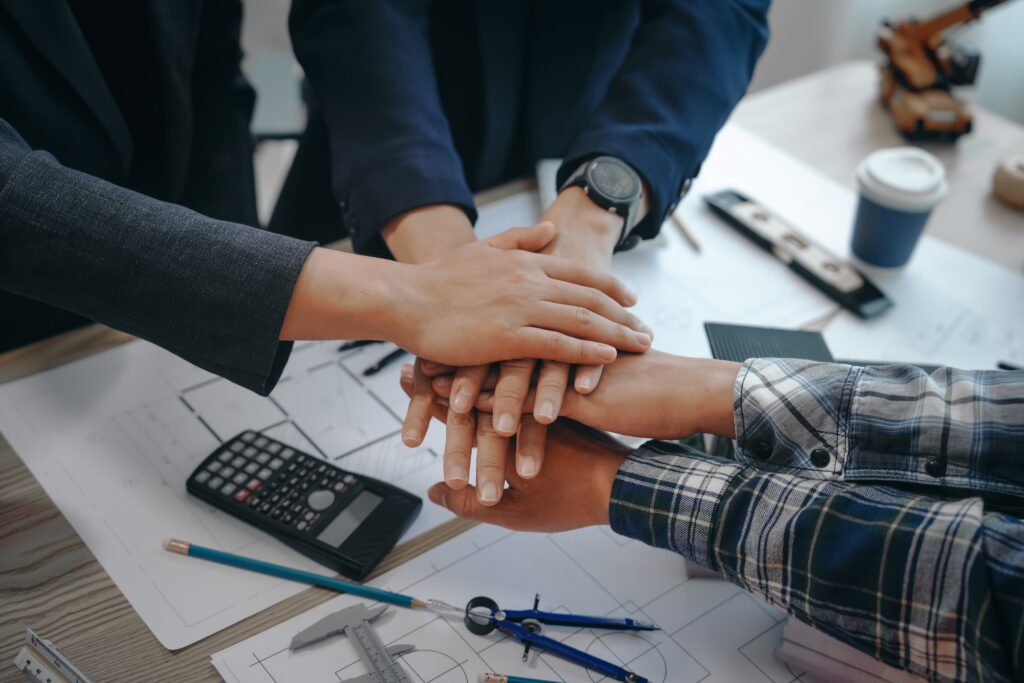 Business sale deal team working together with financial plans and calculator to maximize business value, EBITDA, and sale price.