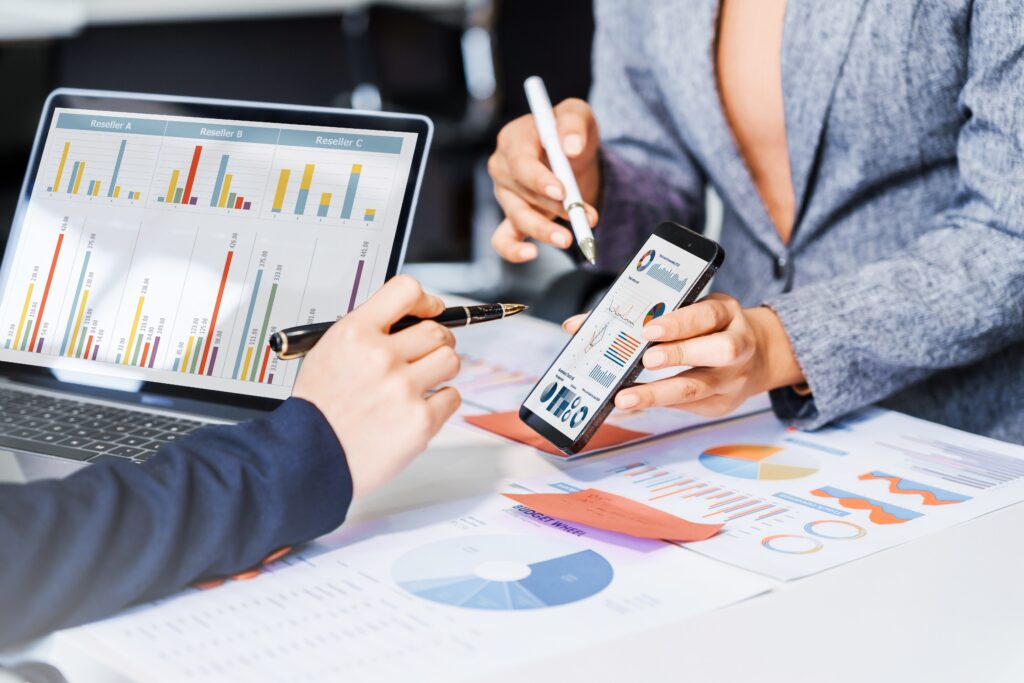 Business owners and financial advisors reviewing business performance charts and financial data while developing a pre-sale tax planning and exit strategy to maximize after-tax proceeds.