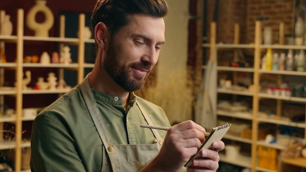 Business owner reviewing operational notes in his workshop, illustrating how strong middle management reduces owner dependency and increases business sale value.
