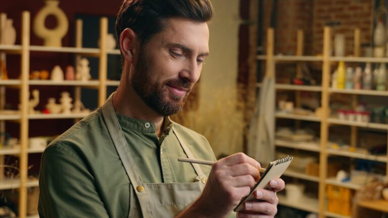 Business owner reviewing operational notes in his workshop, illustrating how strong middle management reduces owner dependency and increases business sale value.